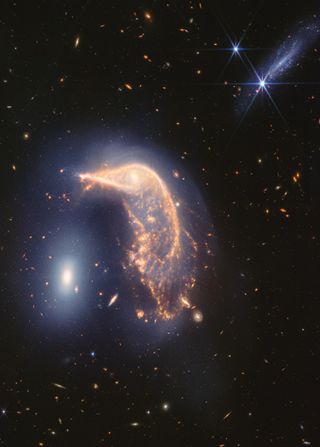 A JWST photo showing a galaxy in the shape of a penguin