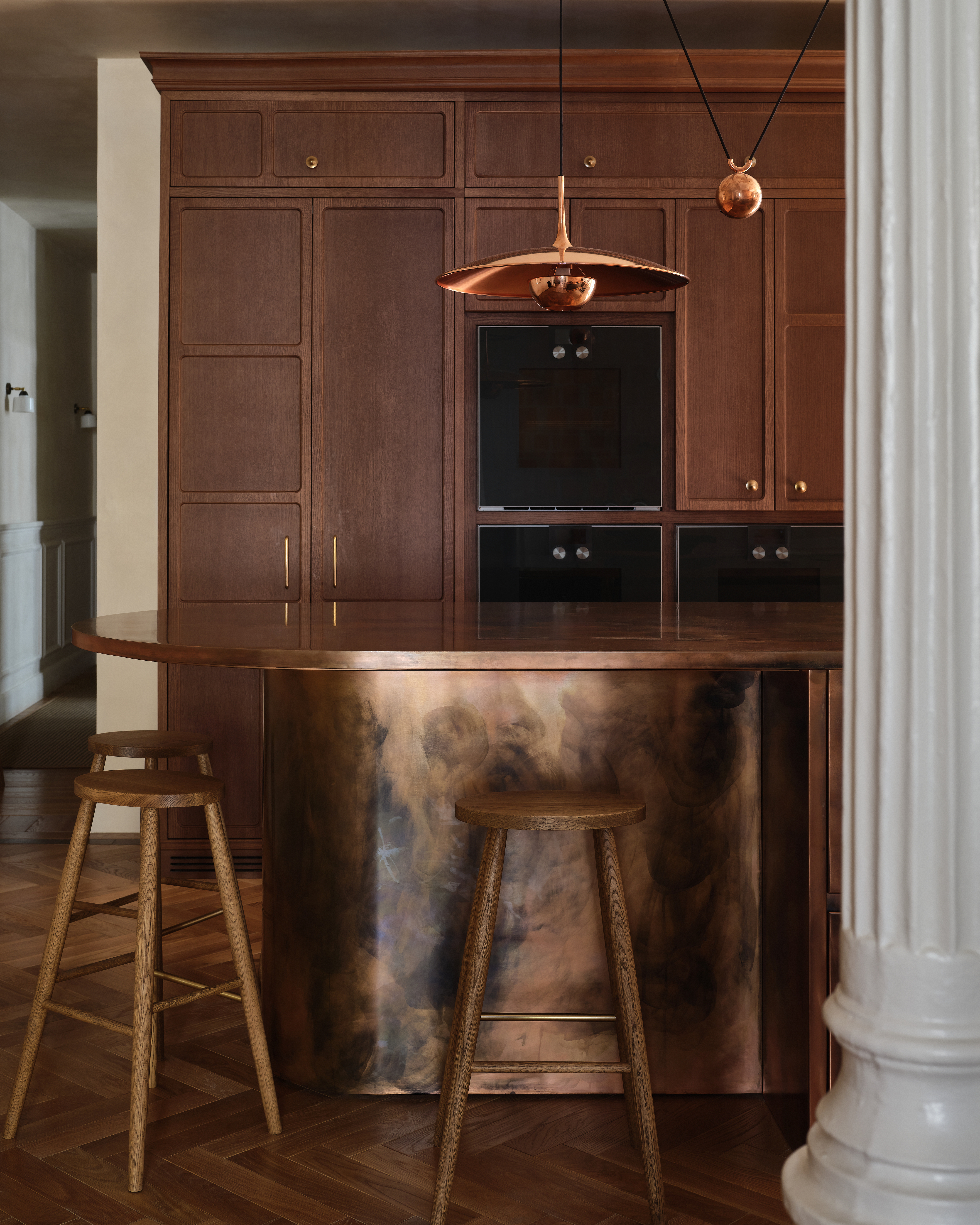 A kitchen with a copper island, and copper lighting