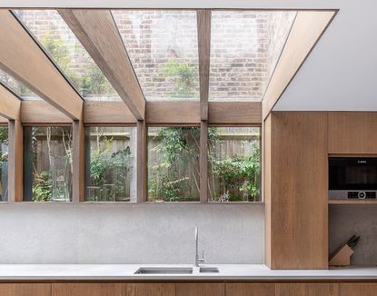 glass box extensions to create an open plan kitchen with wood rafters