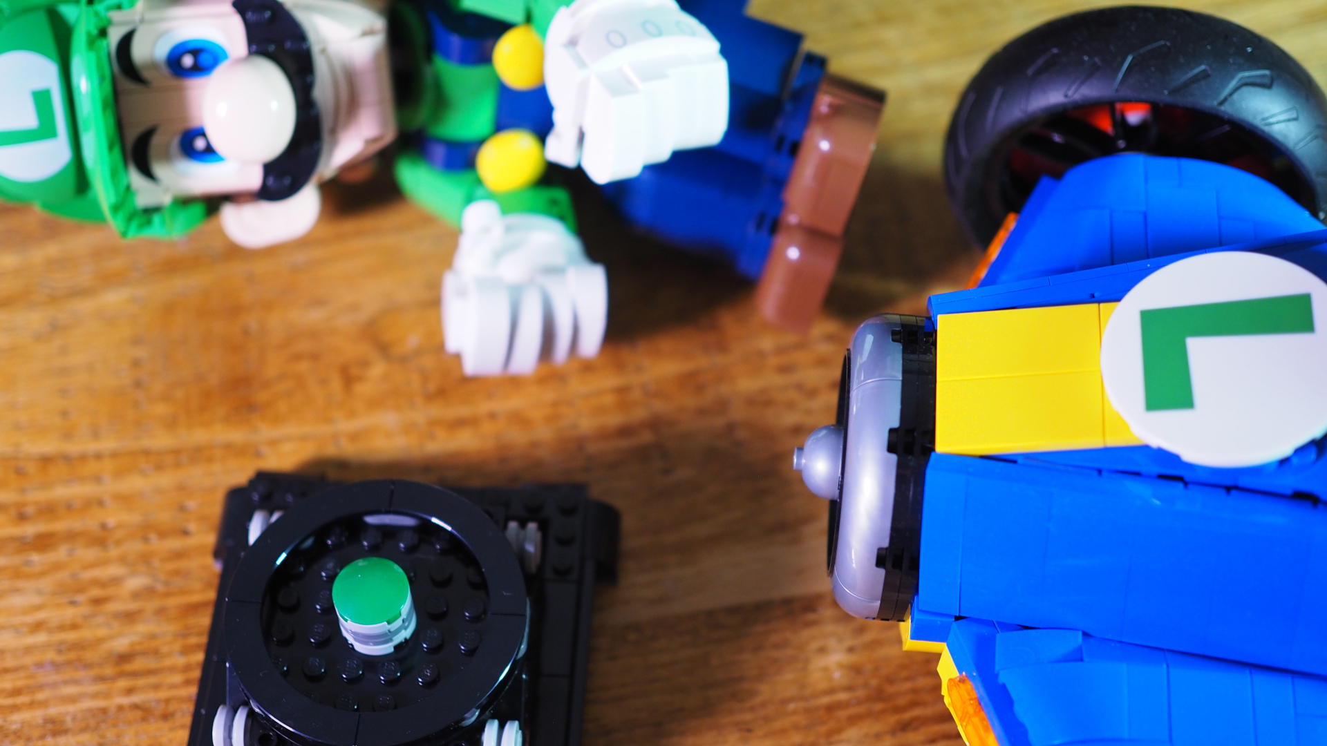 Lego Luigi, the front of the Mach 8 Kart, and the set's stand on a wooden table