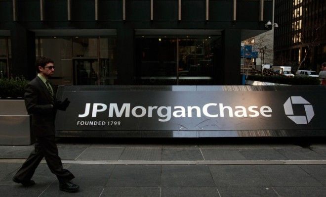 A man walks on the sidewalk in front of the JP Morgan Chase building in New York City.