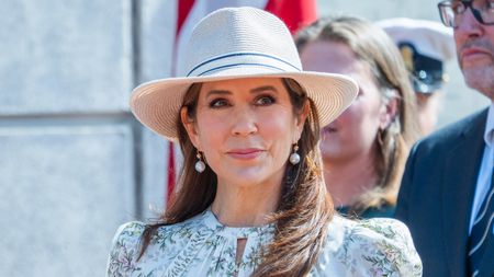 Queen Mary of Denmark, wearing a green floral dress and a sunhat, is welcomed by the public as she arrives in Gråsten