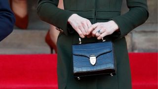 close-up shot of Kate Middleton holding an Aspinal of London handbag