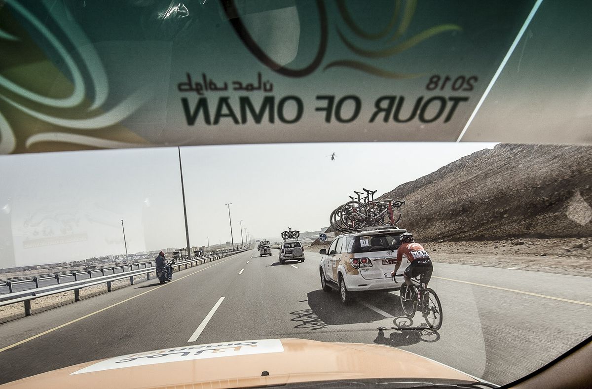 Peering through the windscreen of the team car Tyler Magner finds his way back to the peleton.