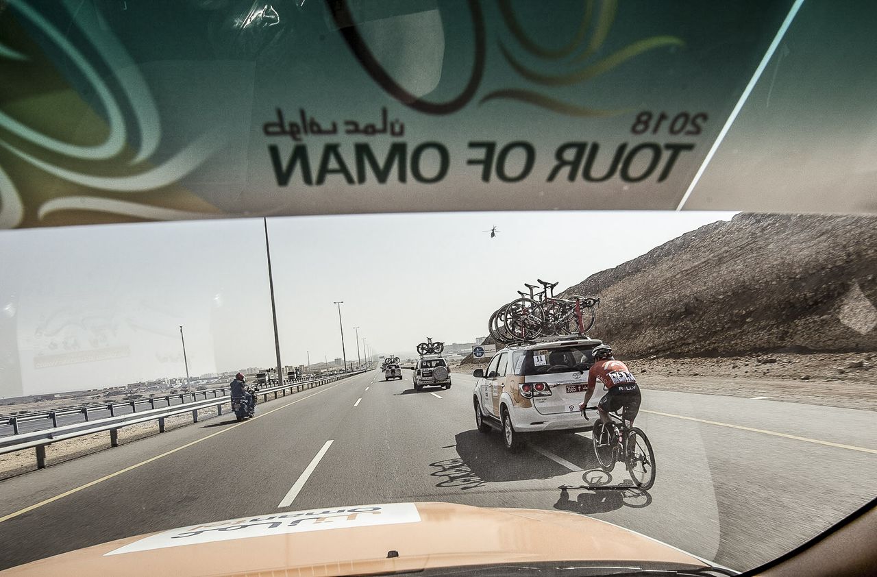 Peering through the windscreen of the team car Tyler Magner finds his way back to the peleton.