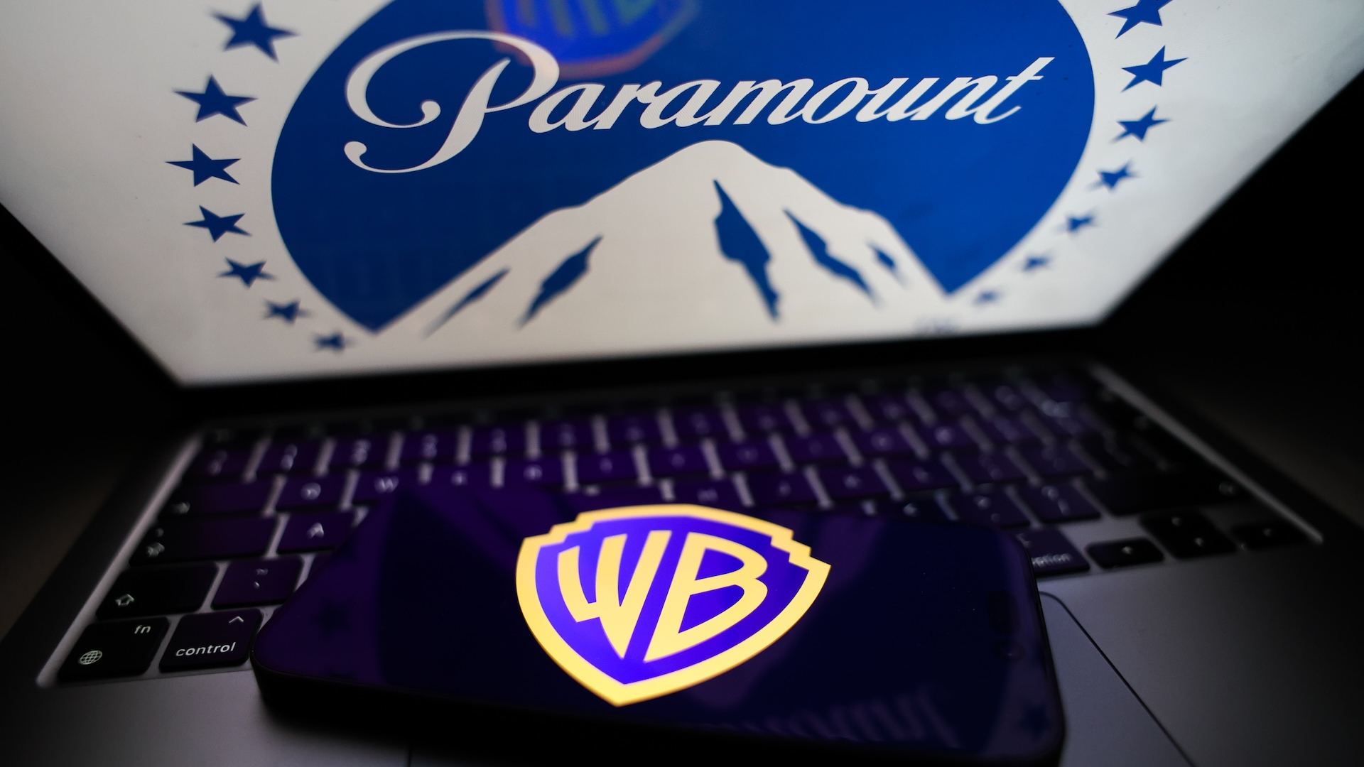 Paramount logo displayed on a laptop screen and Warner Bros logo displayed on a phone screen are seen in this illustration photo taken in Krakow, Poland on February 28, 2026