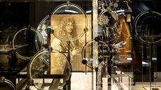A collection of lenses made by Christiaan Huygens with the astronomer's portrait in the background.