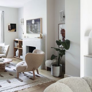 Neutral living room with armchair, houseplant, fireplace