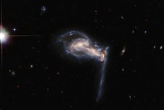 In this image captured by the Hubble Space Telescope, you can see a trio of galaxies, a system known as Arp 195, that is helping scientists to better understand the cosmos. By snapping this image of this system, as it encompasses three different galaxies all tugging back and forth with one another using gravitational forces, astronomers hope to identify even more interesting points in space to study using Hubble in the future, according to NASA.