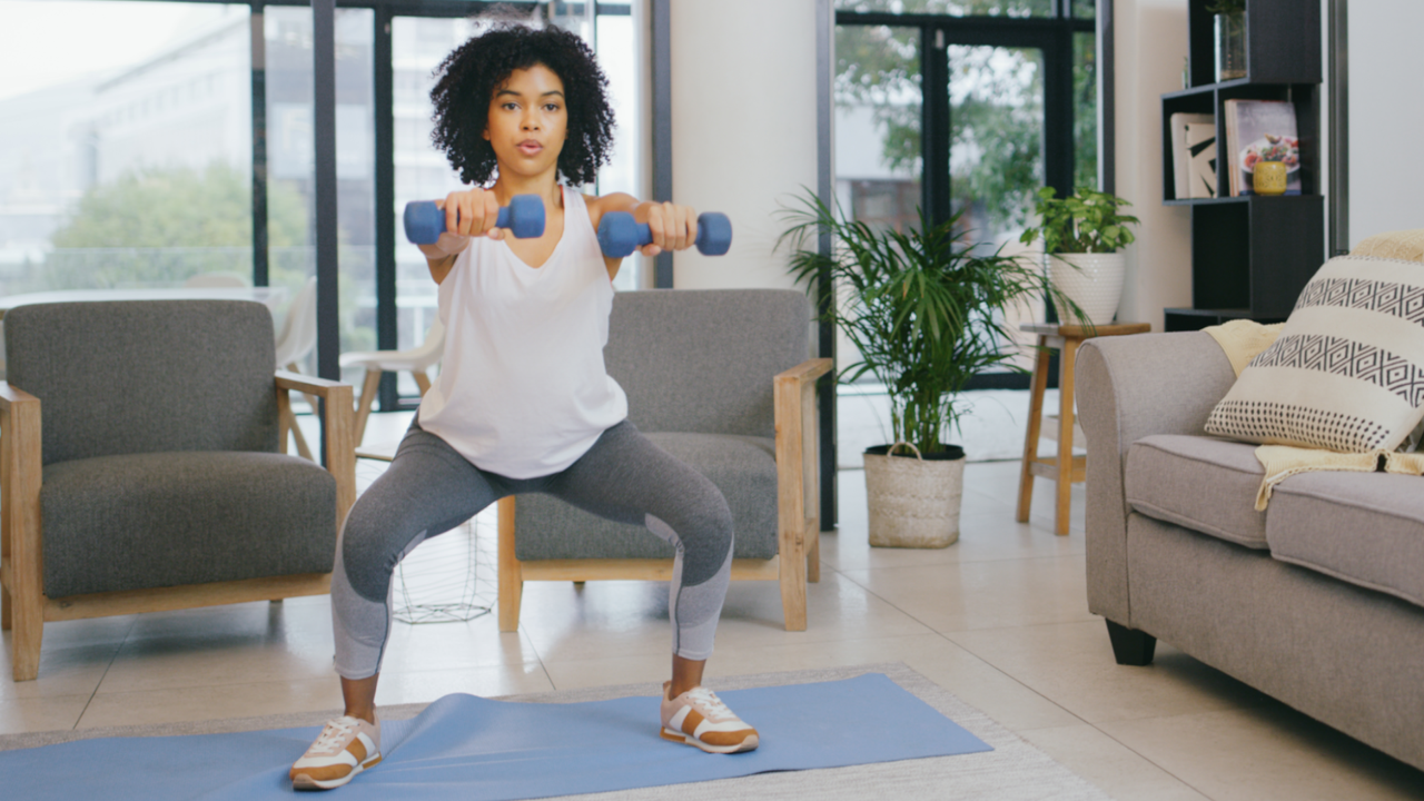 Woman doing squats with dumbbells