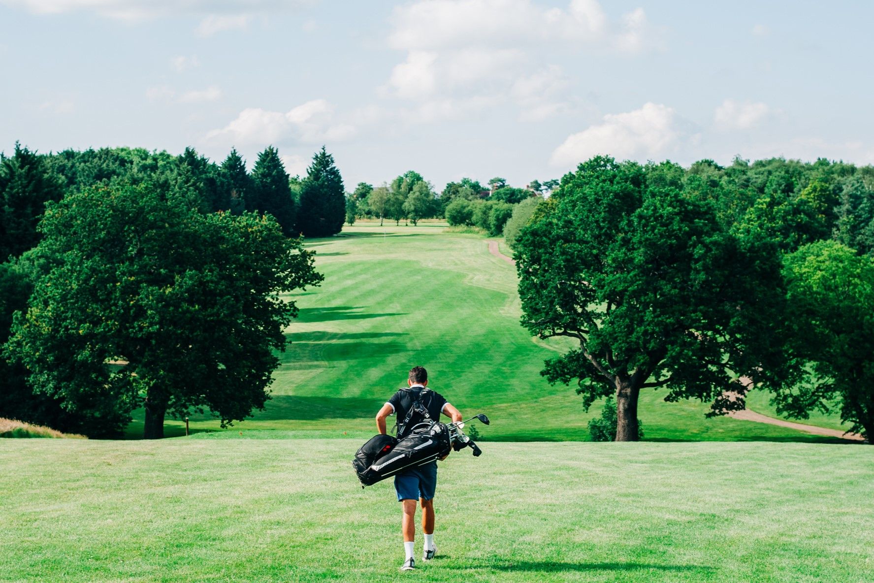 Lone golfer walking down fairway GettyImages-1325736180