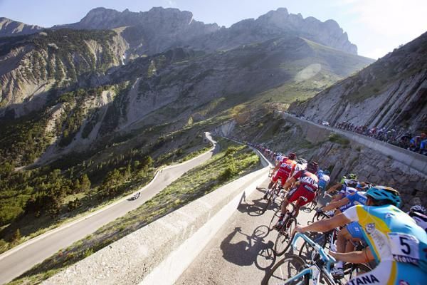 The peloton is stretched out in a long line on the switchbacks of the Col du Noyer descent.
