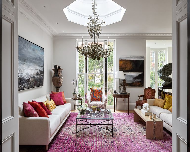 Bright living room with large rug, chandelier and multiple seating areas
