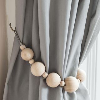 grey coloured curtain with wooden balls