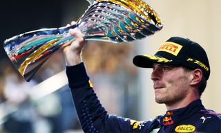 F1 Champion Max Verstappen lifts the trophy on an F1 live stream