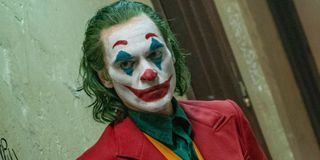 Joker Arthur in full makeup walking down a hall