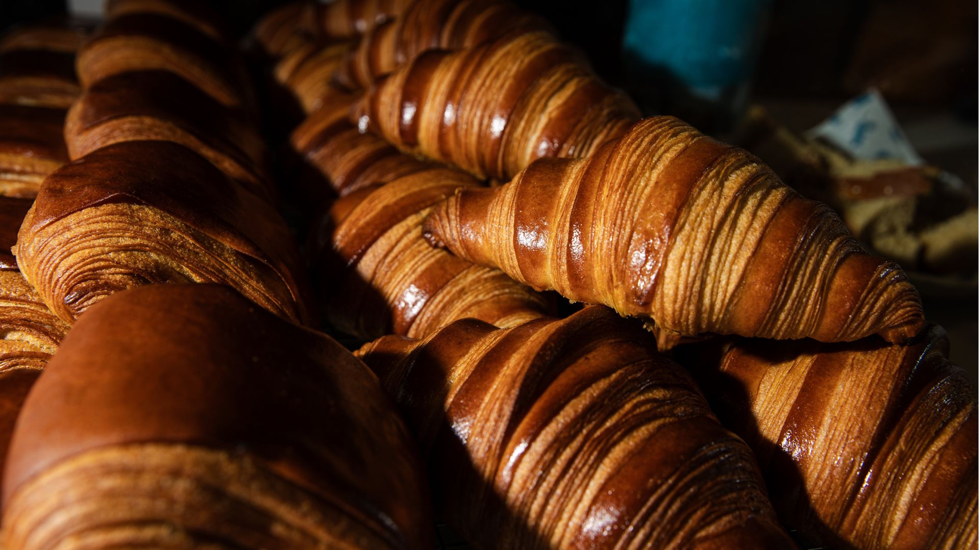 a pile of french style croissants stacked on top of one another in a bakery