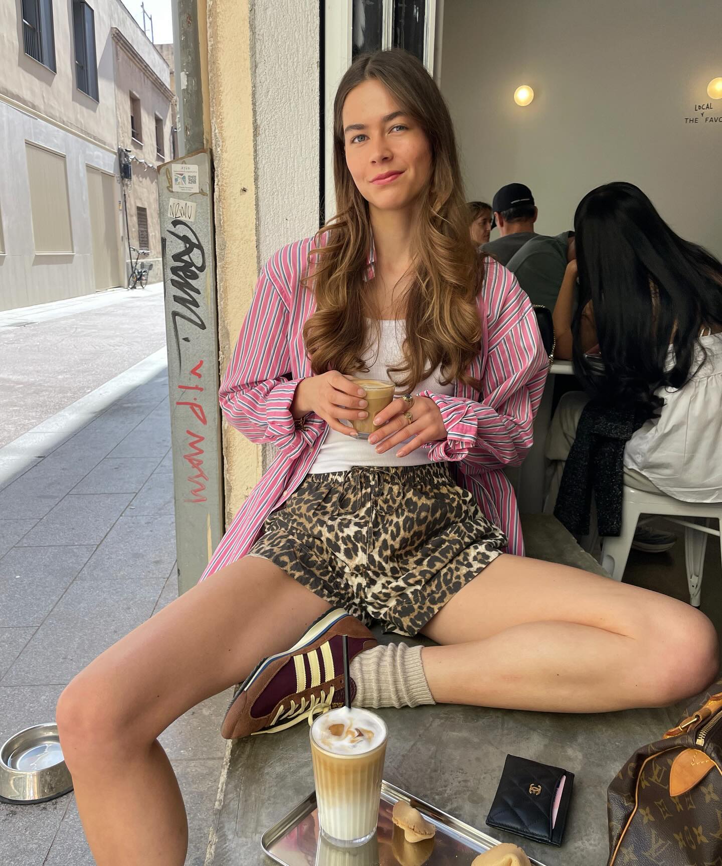 Woman in leopard shorts, tank top and pink stripe shirt