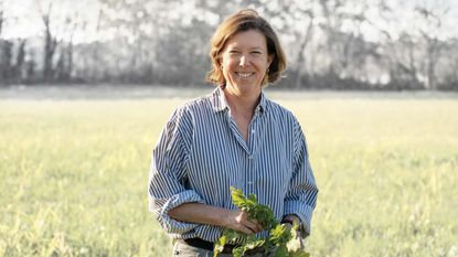 Farm owner Larkin Martin of Courtland, Alabama, stands in a field holding a plant while posing for a photograph