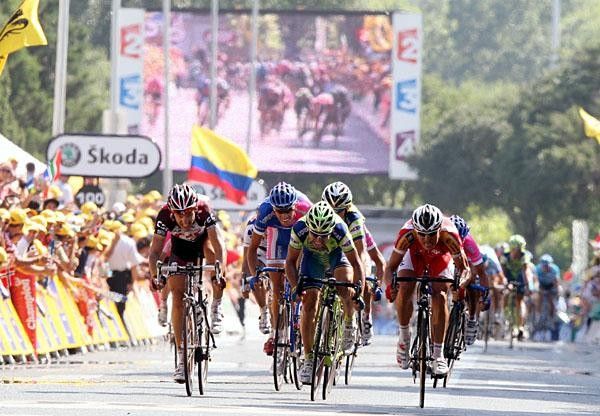 Cancellara and Fisher sprint for podium, while the big screen shows the action live.