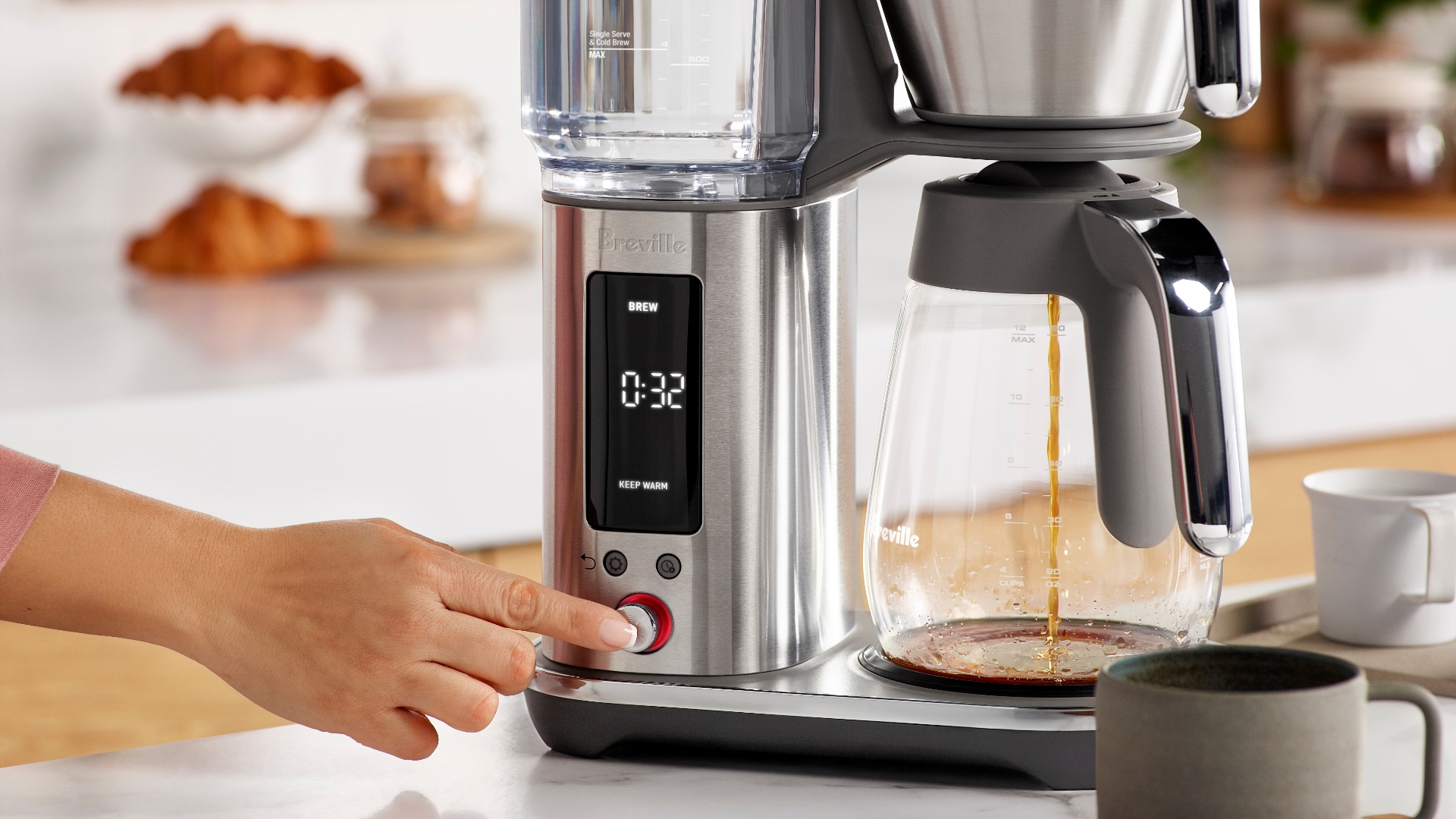 Pressing a button on the interface of the Breville Luxe Brewer