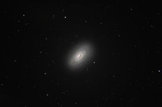 The black eye galaxy shines bright but has a distinct dark patch covering one side of the galaxy center.