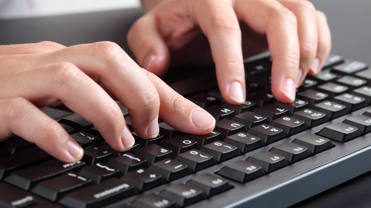 Fingers typing on a computer keyboard.