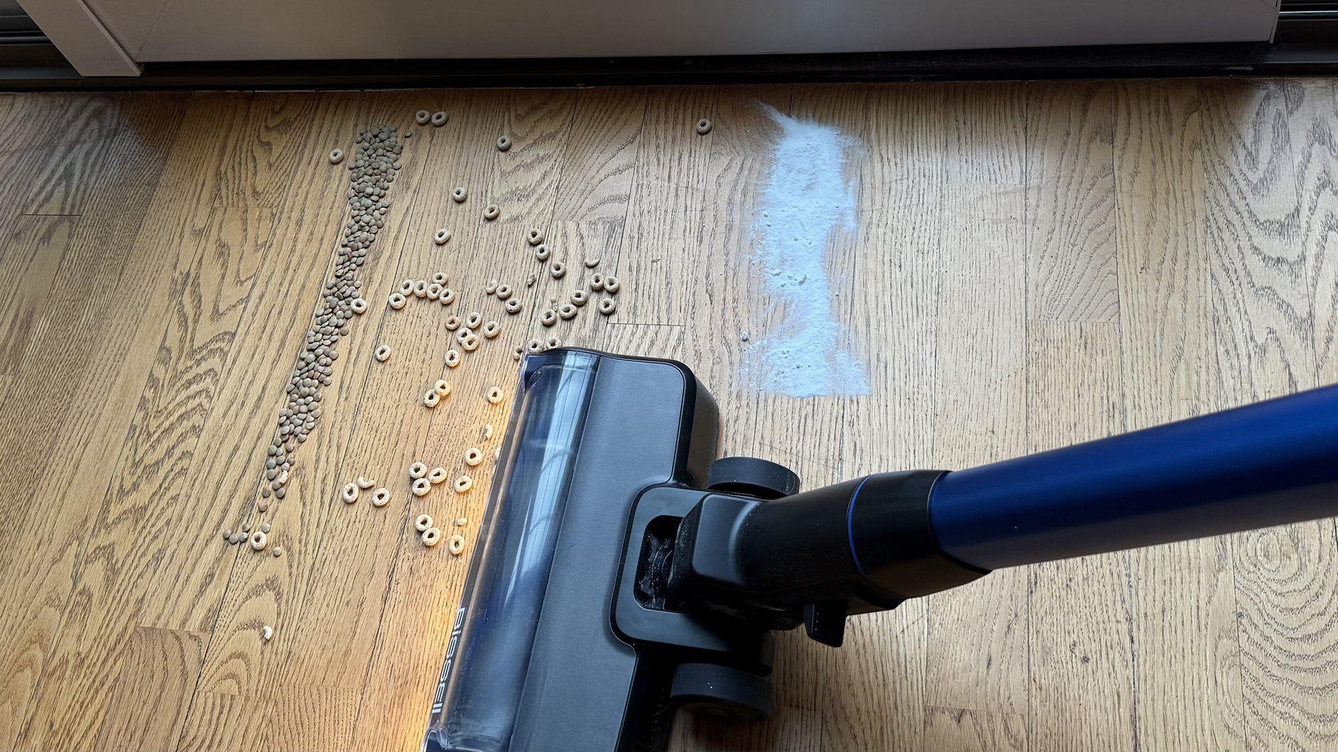 Bissell PowerClean FurFinder cordless vacuum clearing particles off a wooden floor