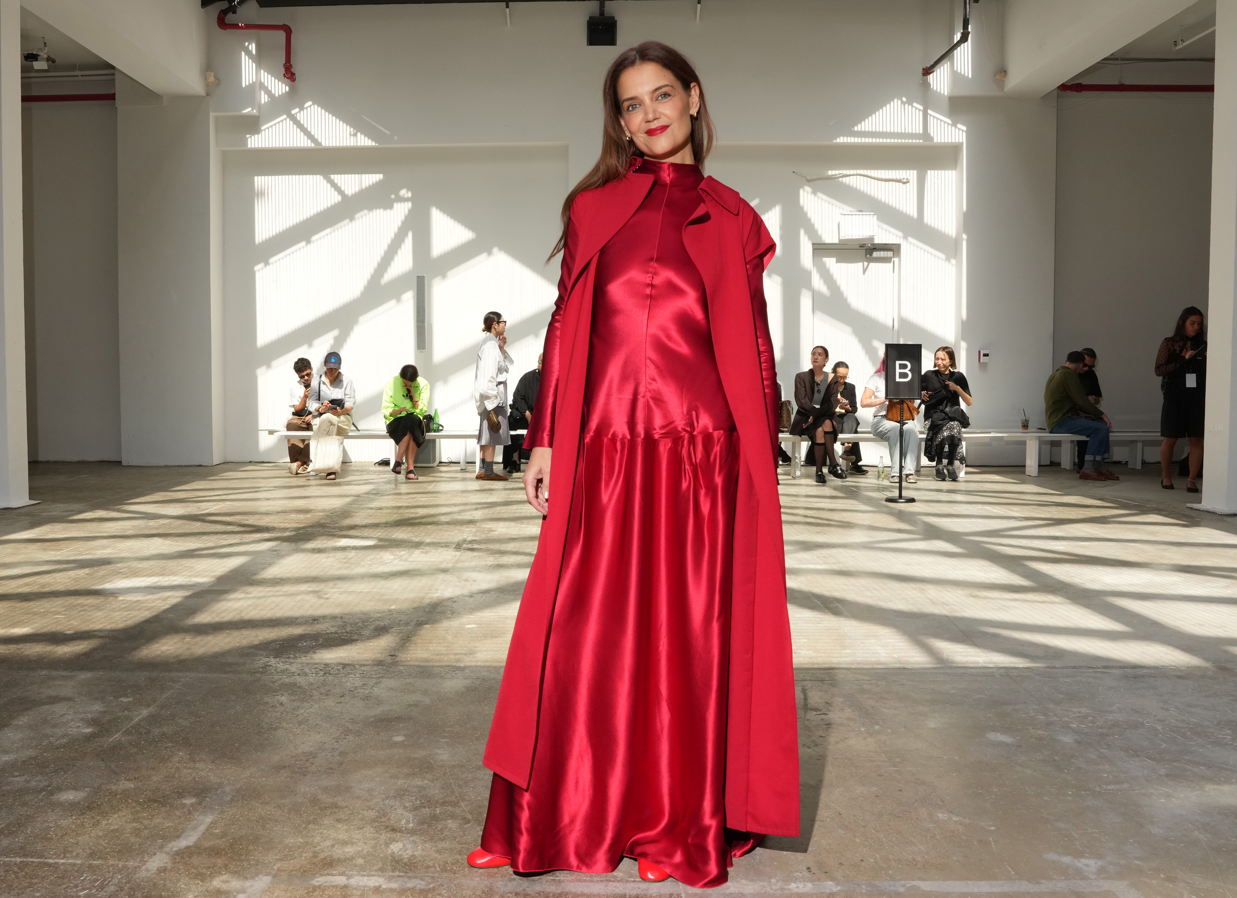 Katie Holmes weres a bright red long-sleeve gown to attend the FFORME S/S26 Show during New York Fashion Week on September 12, 2025