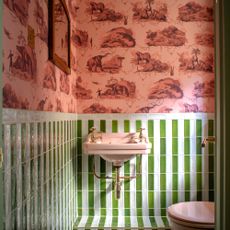 Bathroom with pink wallpaper and green and white tiles