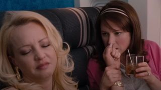 Rita and Becca holding hands on the plane in Bridesmaids.