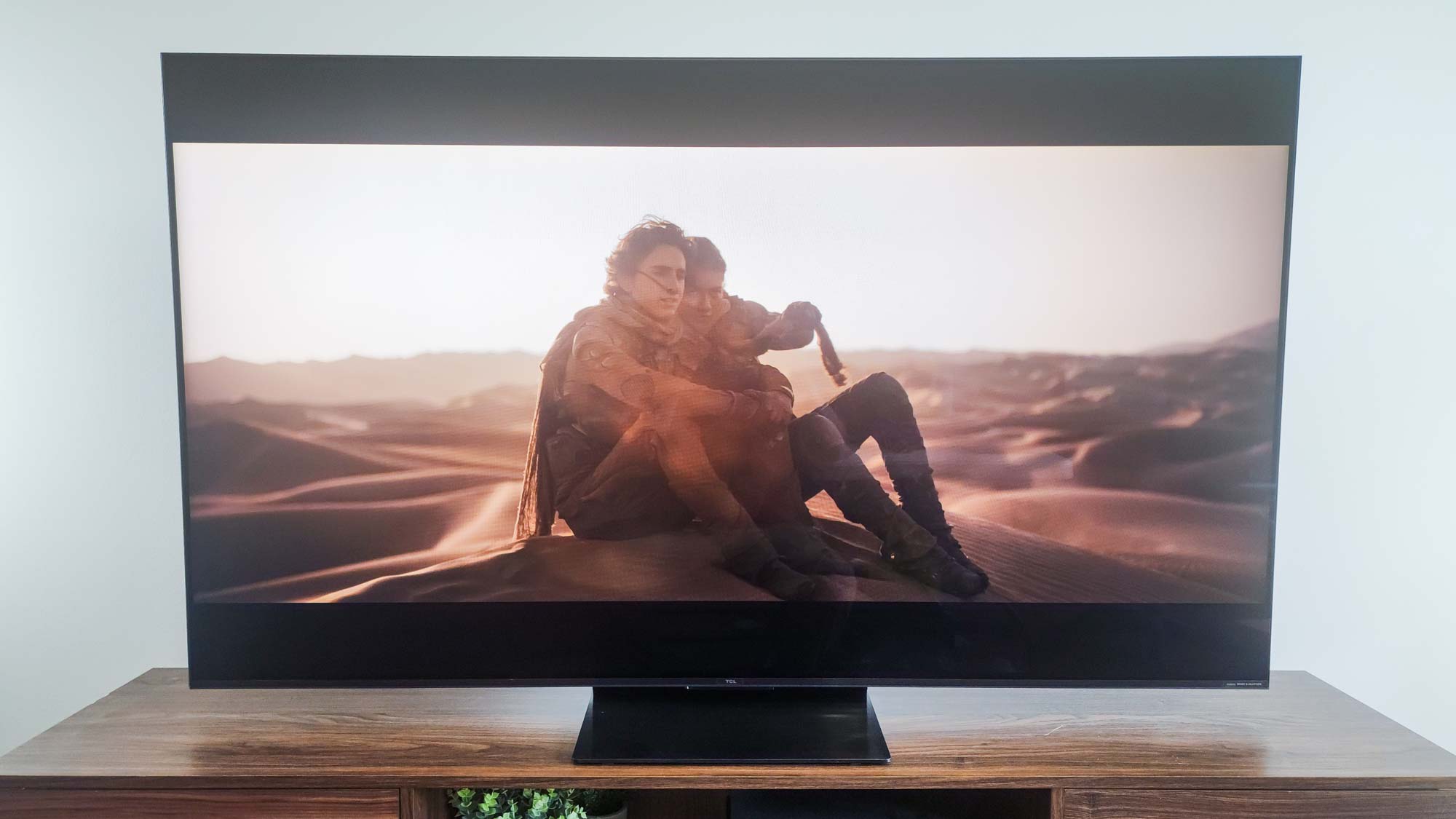 A TCL QM7K QD-Mini LED TV on a side table