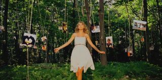 Taylor Swift in a forest full of pictures in the Mine music video