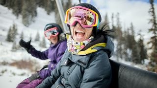 Two women laughing on a ski lift