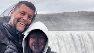 Father and Son happy selfie wearing head nets protection against midges chironomids at powerful waterfall