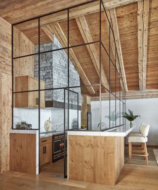 Wooden bar, glass enclosed kitchen, black stove