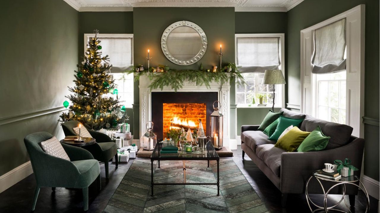 Christmas living room with green walls. Garland on the mantelpiece and Christmas tree in the corner