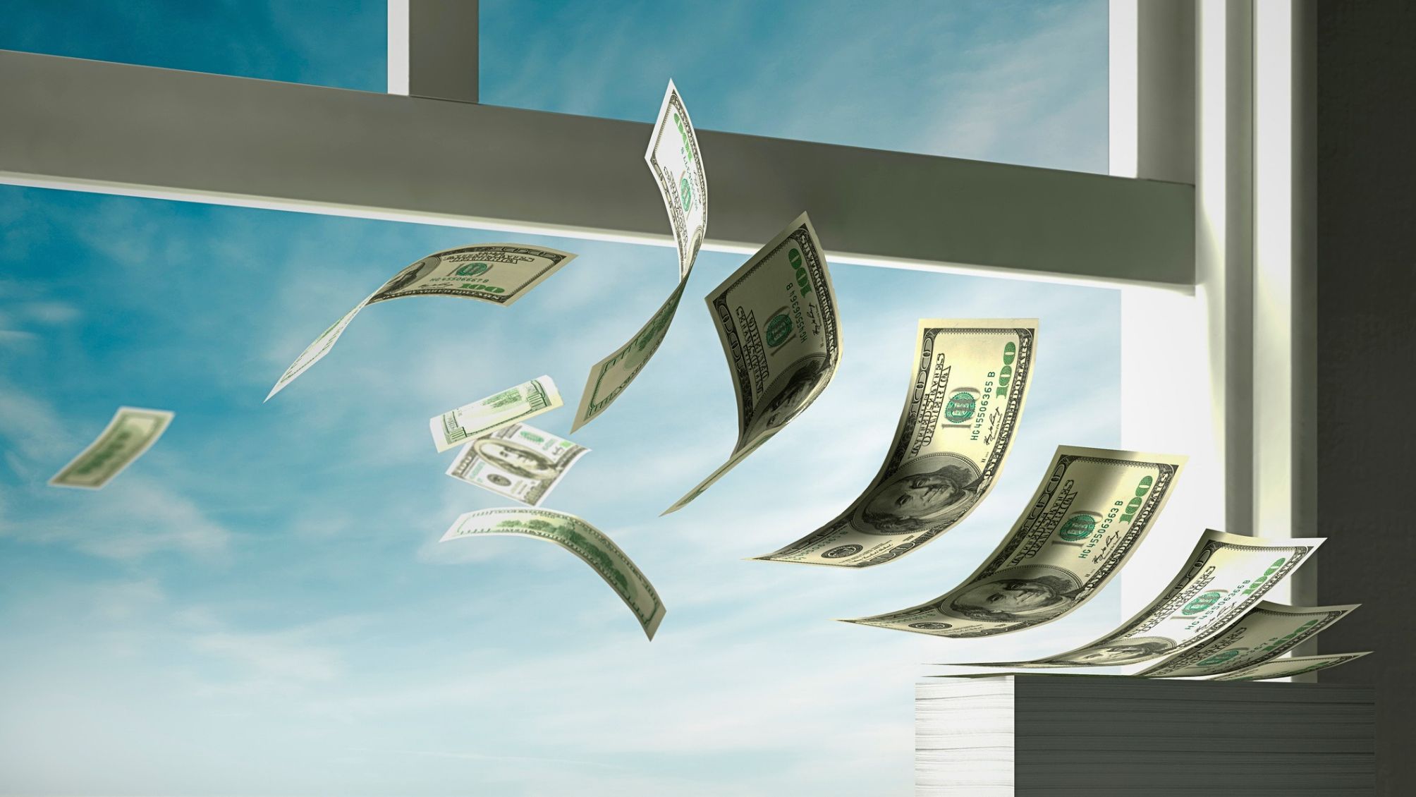 A stack of money floating out of an open window