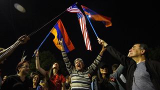 People wave Armenian and US flags in front of the US embassy in Yerevan in April 2021 after President Biden formally designated the slaughter of the Armenians as a ‘genocide’