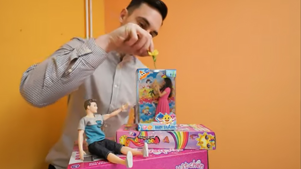 An optical illusion showing what looks like a girl trapped in a doll box while a boy hands her a flower