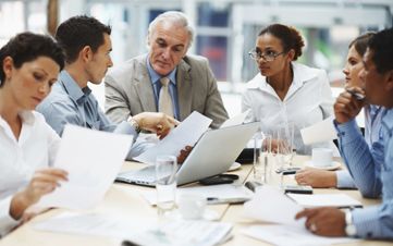 Business people discussing work on laptop at a meeting