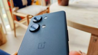 OnePlus Nord 3 ihmisen kädessä pöytää vasten