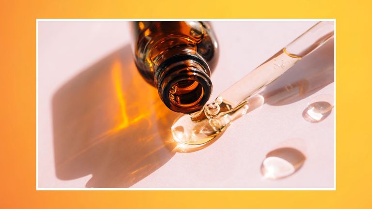 image showing a bottle of serum next to a pipette and drops of serum, on an orange and yellow background—to signify an article on when to apply vitamin c serum, morning or night?
