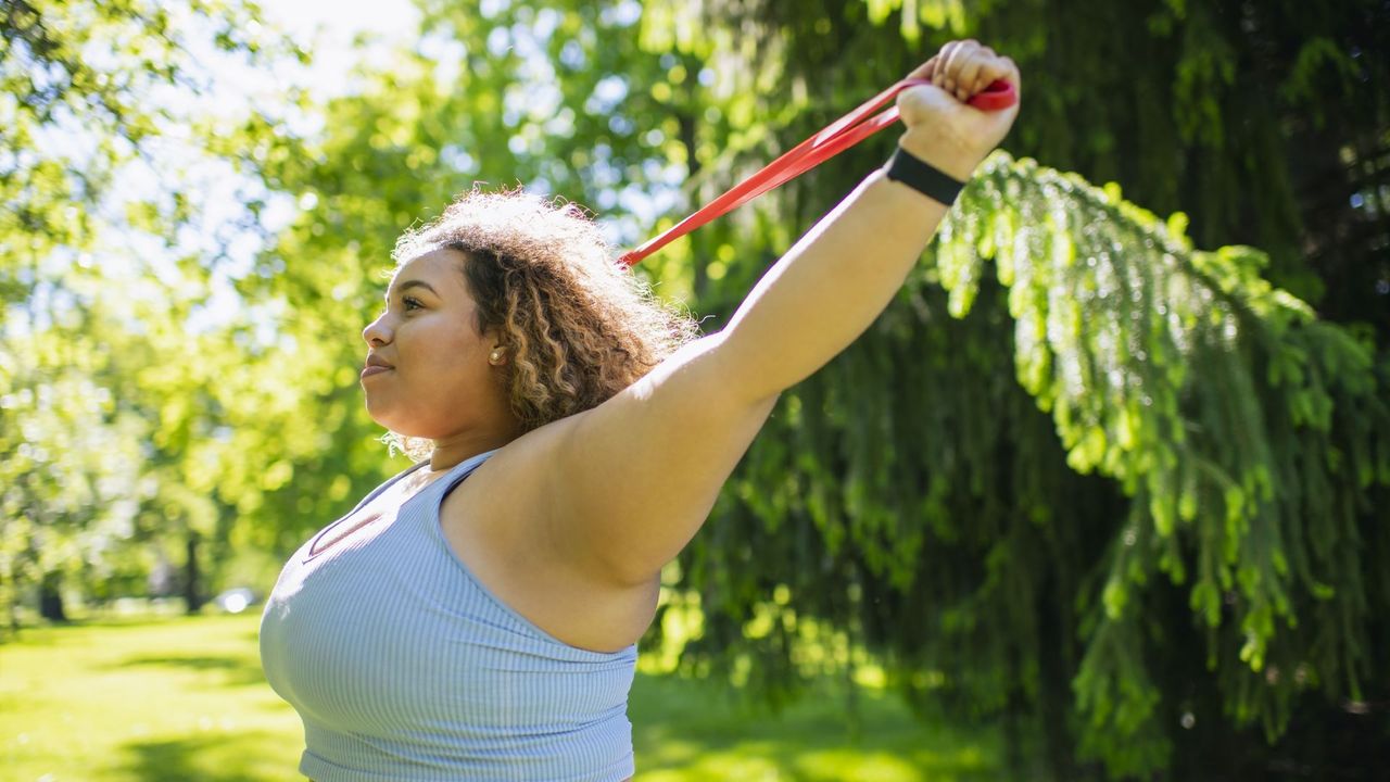 Woman does upper body resistance band workout