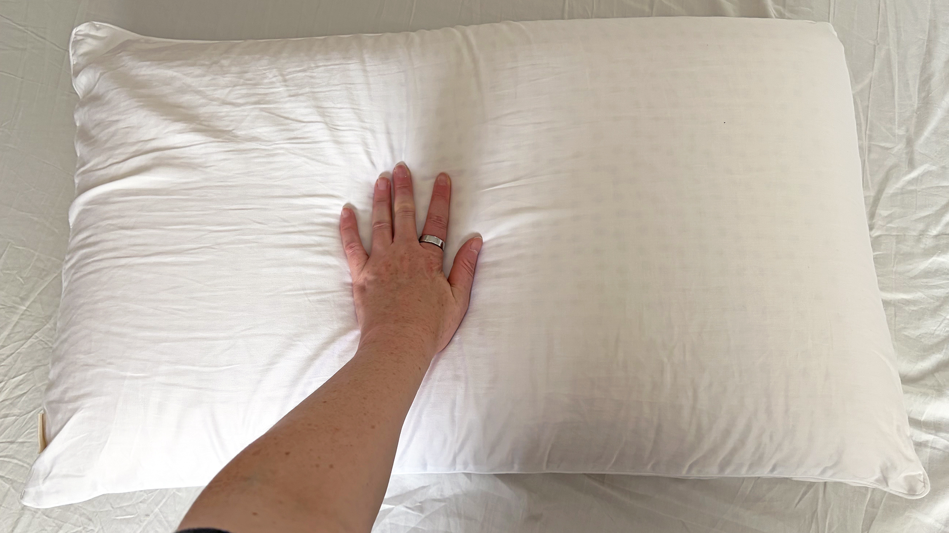 A hand presses into the surface of the Bearaby SoftForm pillow