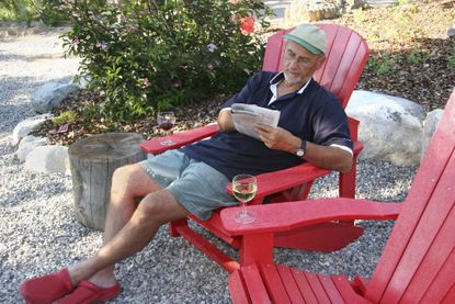 Man Reading The Paper On A Rocky Outdoor Patio Area