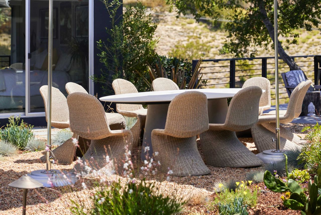 an outdoor table with curved outdoor chairs