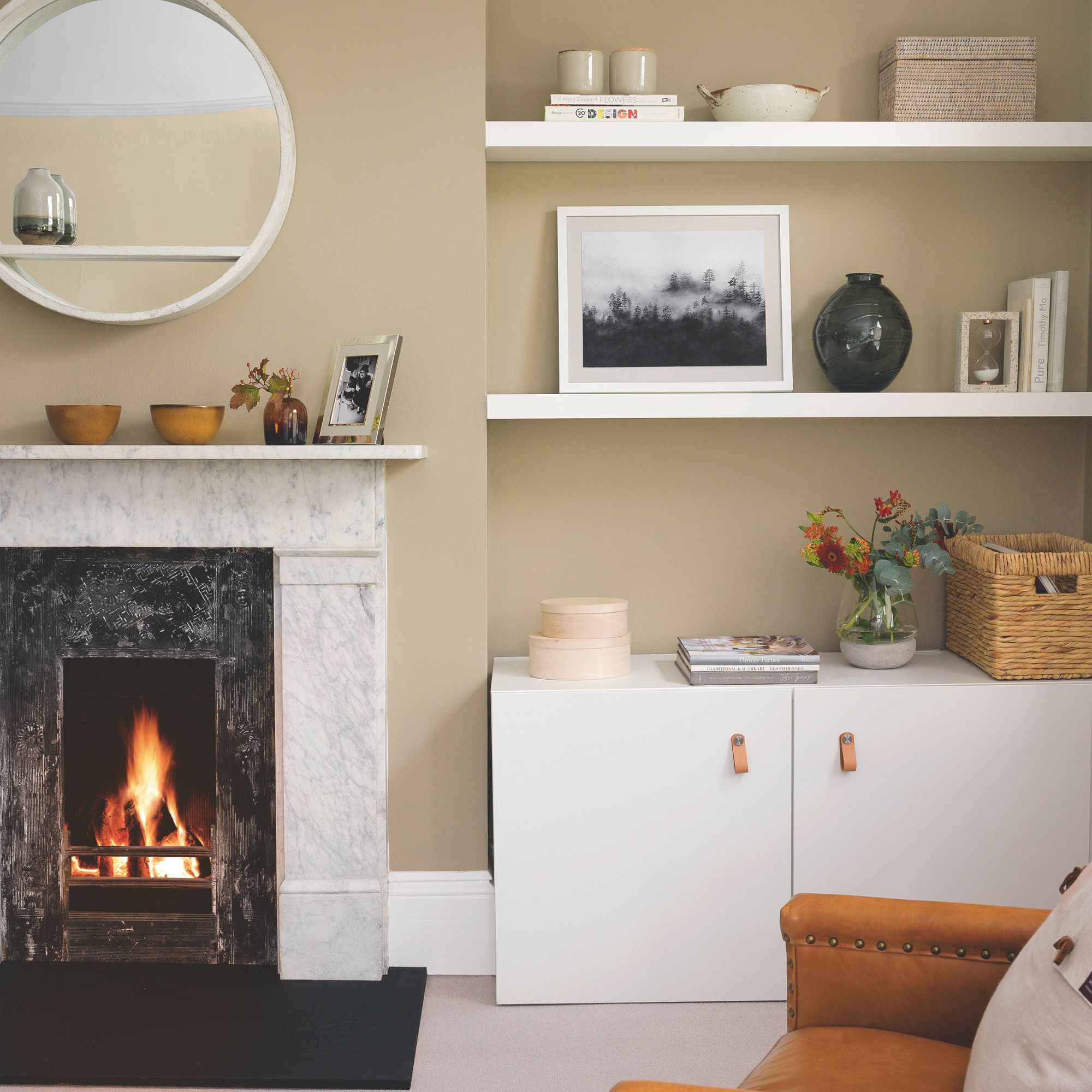 Cosy living room with fireplace, circle mirror and alcove storage