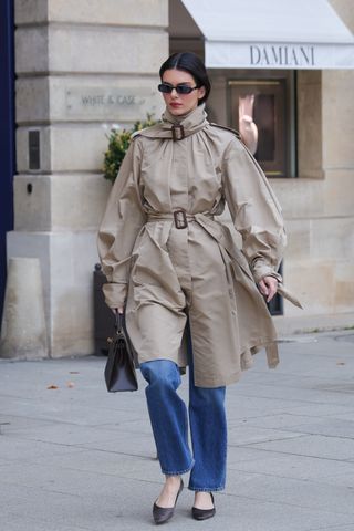 Kendall Jenner walks in Paris wearing a double belted trench coat with an Hermes Kelly bag and kitten heels by The Row