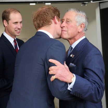 Prince Charles, Prince of Wales kisses his son Prince Harry as Prince William, Duke of Cambridge looks on ahead of the Invictus Games Opening Ceremony at Queen Elizabeth II Park on September 10, 2014 in London, England.